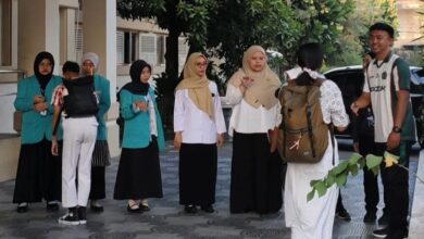 Mahasiswa PLP 2 UMS menyambut dan berinteraksi ramah dengan siswa SMPN 1 Surakarta di area halaman sekolah.