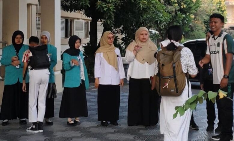 Mahasiswa PLP 2 UMS menyambut dan berinteraksi ramah dengan siswa SMPN 1 Surakarta di area halaman sekolah.
