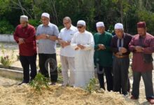Sekelompok Muslim melaksanakan salat jenazah di dekat makam setelah proses pemakaman.