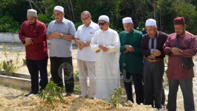 Sekelompok Muslim melaksanakan salat jenazah di dekat makam setelah proses pemakaman.