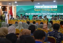 Suasana Sidang Senat Terbuka di aula UNIMUS, Semarang, untuk merayakan Milad ke-27. Terlihat panggung dengan anggota senat dalam jubah akademik lengkap duduk di belakang meja, dan spanduk hijau besar bertuliskan "Rapat Terbuka Senat Dalam Rangka MILAD UNIVERSITAS MUHAMMADIYAH SEMARANG Ke-27 Tahun". Audiens terlihat duduk di depan.