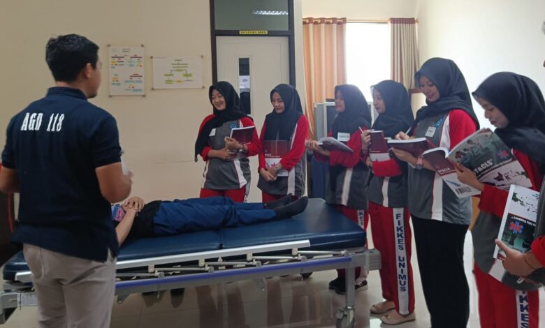Sekelompok mahasiswa D3 Keperawatan UNIMUS sedang menyimak penjelasan instruktur saat simulasi penanganan pasien dalam pelatihan BTCLS UNIMUS 2026.