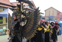 Seorang siswa SMK Muhammadiyah Kedungwuni mengenakan kostum megah daur ulang bernuansa hitam emas dalam Karnaval HUT RI Pekalongan.