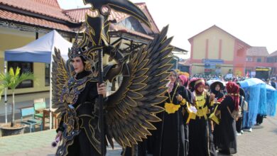 Seorang siswa SMK Muhammadiyah Kedungwuni mengenakan kostum megah daur ulang bernuansa hitam emas dalam Karnaval HUT RI Pekalongan.