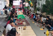 Warga RT 05 RW 05 Perum Gedangan Sektor 9 Sukoharjo duduk lesehan menikmati hidangan tumpeng dan jajanan dalam acara Malam Tirakatan HUT RI.