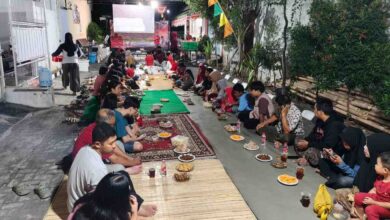 Warga RT 05 RW 05 Perum Gedangan Sektor 9 Sukoharjo duduk lesehan menikmati hidangan tumpeng dan jajanan dalam acara Malam Tirakatan HUT RI.