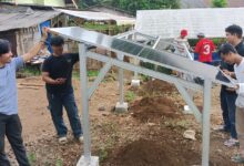 Tim pengabdian UMP merakit kerangka panel surya untuk mendukung sistem budidaya ikan nila bioflok di Banyumas.