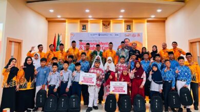 Puluhan pelajar Muhammadiyah berfoto bersama pengurus Lazismu Jepara sambil membawa tas ransel dan papan simbolis penerimaan beasiswa pendidikan Mentari di Aula PPNI.