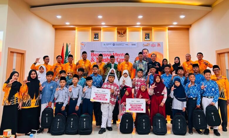 Puluhan pelajar Muhammadiyah berfoto bersama pengurus Lazismu Jepara sambil membawa tas ransel dan papan simbolis penerimaan beasiswa pendidikan Mentari di Aula PPNI.