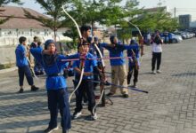 Kelompok siswa SD Muhammadiyah PK Solo sedang fokus latihan memanah di area parkir luar ruangan sebagai bagian dari kegiatan ekstrakurikuler