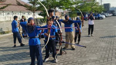 Kelompok siswa SD Muhammadiyah PK Solo sedang fokus latihan memanah di area parkir luar ruangan sebagai bagian dari kegiatan ekstrakurikuler