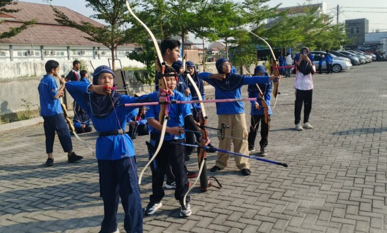 Kelompok siswa SD Muhammadiyah PK Solo sedang fokus latihan memanah di area parkir luar ruangan sebagai bagian dari kegiatan ekstrakurikuler