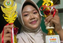 Amira Nugraheni Syahida, siswi SMP Mutual Kota Magelang, menunjukkan dua piala juara Borobudur Line Dance yang diraihnya.