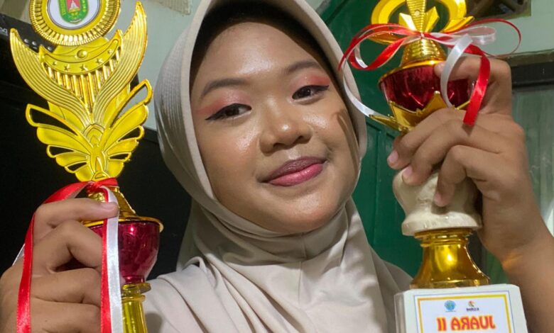Amira Nugraheni Syahida, siswi SMP Mutual Kota Magelang, menunjukkan dua piala juara Borobudur Line Dance yang diraihnya.