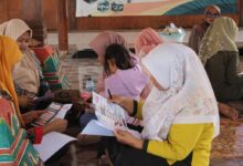 Ibu PKK Desa Kalisalak membaca brosur edukasi pencegahan anemia dan PHBS dari Tim PPK Ormawa UMP.