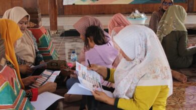 Ibu PKK Desa Kalisalak membaca brosur edukasi pencegahan anemia dan PHBS dari Tim PPK Ormawa UMP.