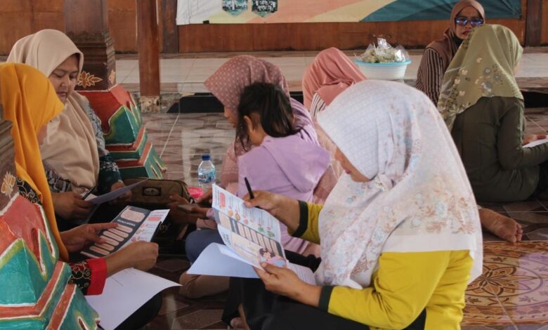 Ibu PKK Desa Kalisalak membaca brosur edukasi pencegahan anemia dan PHBS dari Tim PPK Ormawa UMP.