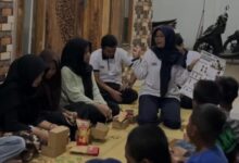 Mahasiswa fisioterapi UMS memegang poster saat memberikan edukasi pencegahan skoliosis pada remaja yang sedang duduk berkumpul di Posyandu Tawangsari.
