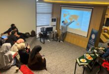 Fauzul Hanif Noor Athief (Wakil Dekan FAI UMS) sedang memberikan materi presentasi mengenai tata kelola zakat kepada jajaran pengurus Lazismu Pakistan dalam sesi pelatihan penguatan kelembagaan di sebuah ruangan pertemuan amphitheater modern.