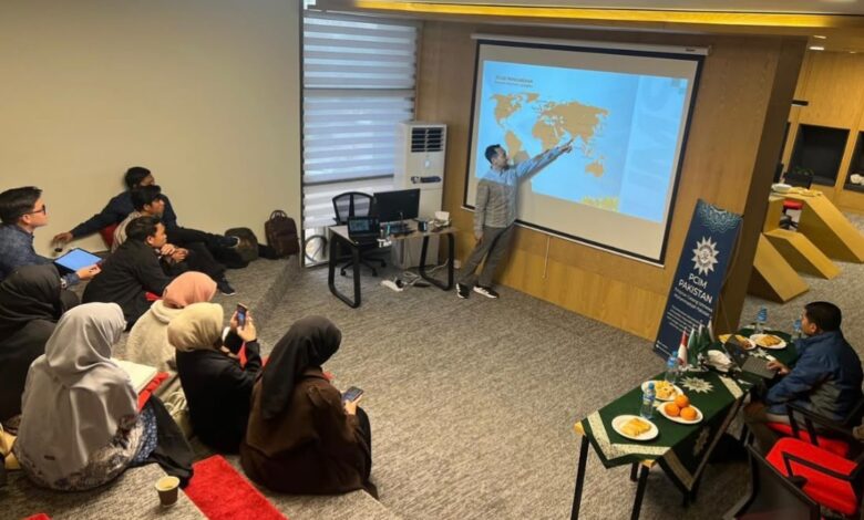 Fauzul Hanif Noor Athief (Wakil Dekan FAI UMS) sedang memberikan materi presentasi mengenai tata kelola zakat kepada jajaran pengurus Lazismu Pakistan dalam sesi pelatihan penguatan kelembagaan di sebuah ruangan pertemuan amphitheater modern.