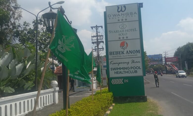 Deretan bendera hijau Muktamar Nasyiatul Aisyiyah terpasang di trotoar pinggir jalan raya depan area Syariah Hotel Solo.