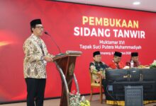 Pria berpeci memberikan sambutan di podium dengan latar belakang layar bertuliskan "Pembukaan Sidang Tanwir Muktamar XVI Tapak Suci" di Semarang.