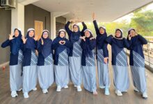Sembilan anggota tim tari kreasi PDNA Temanggung mengenakan seragam olahraga biru dongker dan abu-abu berpose ceria sebelum tampil di pra-acara pembukaan Muktamar Nasyiatul Aisyiyah XV di Surakarta.
