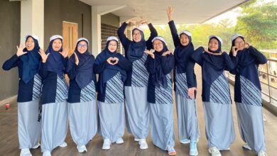Sembilan anggota tim tari kreasi PDNA Temanggung mengenakan seragam olahraga biru dongker dan abu-abu berpose ceria sebelum tampil di pra-acara pembukaan Muktamar Nasyiatul Aisyiyah XV di Surakarta.