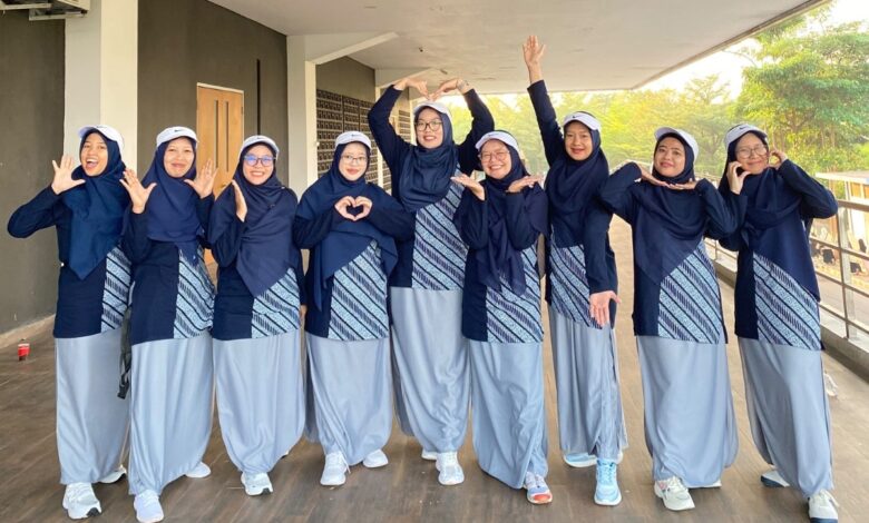 Sembilan anggota tim tari kreasi PDNA Temanggung mengenakan seragam olahraga biru dongker dan abu-abu berpose ceria sebelum tampil di pra-acara pembukaan Muktamar Nasyiatul Aisyiyah XV di Surakarta.