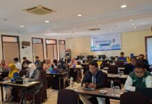 Suasana ruang rapat Pelatihan Asesor Kompetensi Batch 4 LSP UMS yang dihadiri oleh peserta dan pemateri di depan, lengkap dengan spanduk digital di layar proyektor.
