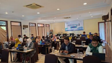 Suasana ruang rapat Pelatihan Asesor Kompetensi Batch 4 LSP UMS yang dihadiri oleh peserta dan pemateri di depan, lengkap dengan spanduk digital di layar proyektor.