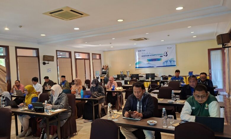 Suasana ruang rapat Pelatihan Asesor Kompetensi Batch 4 LSP UMS yang dihadiri oleh peserta dan pemateri di depan, lengkap dengan spanduk digital di layar proyektor.