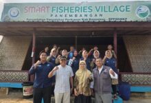 Kelompok pengelola Desa Wisata Panembangan, Kabupaten Banyumas, berfoto bersama tim dosen UMP di depan gazebo dengan spanduk "SMART FISHERIES VILLAGE", menandai dimulainya digitalisasi destinasi wisata berbasis komunitas.