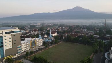 Pemandangan udara Kampus Utama UMP Purwokerto dengan latar belakang Gunung Slamet di pagi hari, menunjukkan fasilitas modern yang mendukung riset dan pencapaian peringkat SINTA nasional.