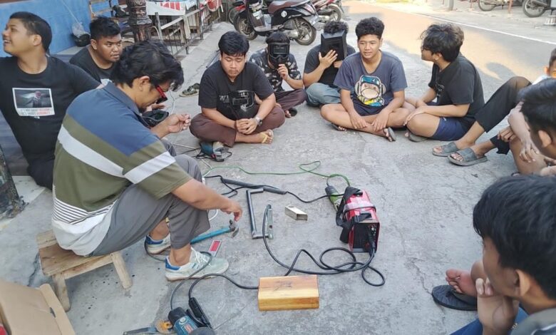 Hammam Effendy, pemilik bengkel las, memberikan penjelasan mengenai prinsip kerja las listrik dan pengenalan peralatan kepada pemuda Karang Taruna Jajar di Surakarta.