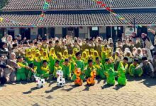 Siswa MI Wahid Hasyim dan mahasiswa KKNMAs Kelompok 12 foto bersama memamerkan kreasi botol bekas media tanam berbentuk karakter hewan.
