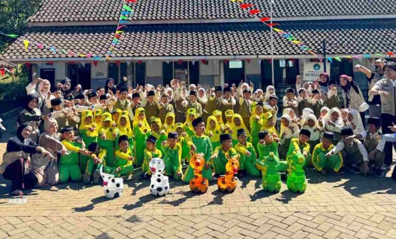 Siswa MI Wahid Hasyim dan mahasiswa KKNMAs Kelompok 12 foto bersama memamerkan kreasi botol bekas media tanam berbentuk karakter hewan.