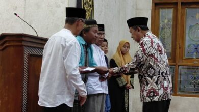Pria berbatik memberikan santunan kepada warga dalam acara Peringatan Maulid Nabi di Masjid Nurul ‘Aini, Karanggeneng, Boyolali, disaksikan oleh tokoh PRM Karanggeneng dan Lazismu.