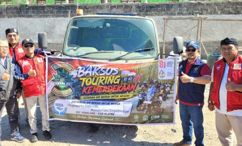 Pengurus BikersMU Klaten membentangkan spanduk Baksos Touring Kemerdekaan RI ke-81 di depan truk tangki bantuan air bersih Kemalang.