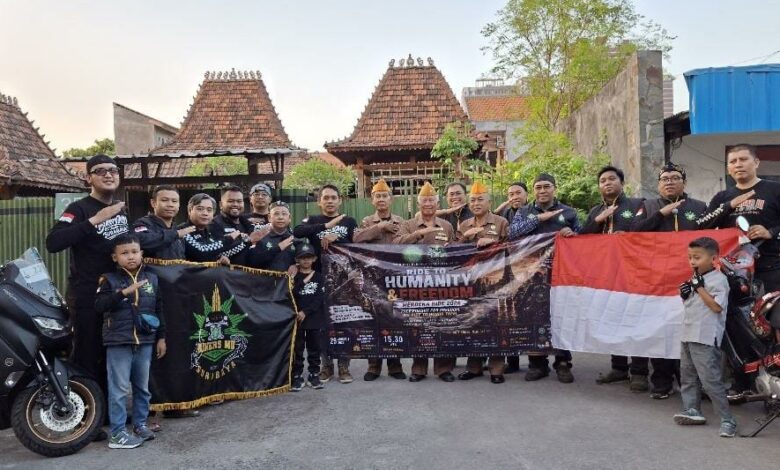 Anggota BikersMu Surabaya foto bersama para veteran perang memegang bendera Merah Putih dan spanduk kegiatan Ride to Humanity and Freedom.