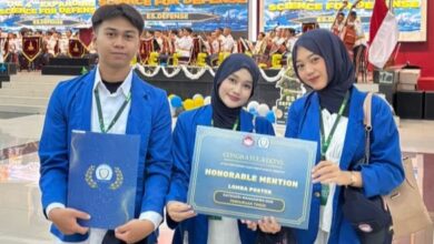 Tim mahasiswa Farmasi UMP pemenang Honorable Mention dalam lomba poster nasional Expanding Science Defense ke-4 di Universitas Pertahanan, memegang sertifikat penghargaan dan map di atas panggung dengan latar belakang spanduk acara dan kelompok paduan suara.