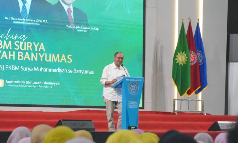 Bupati Banyumas, Sadewo Tri Lastiono, memberikan sambutan di podium UMP saat peluncuran PKBM Surya Muhammadiyah Banyumas, Ahad (9/8/2026). Di belakangnya terdapat layar besar acara dan tiga bendera panji.