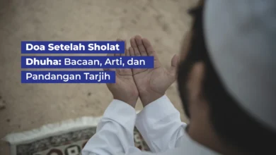 Seorang pria Muslim berbaju putih mengangkat kedua tangan berdoa setelah sholat dhuha di atas sajadah.
