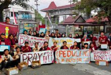Mahasiswa IMM Sukoharjo membentangkan spanduk penggalangan dana peduli korban gempa NTT di depan gerbang UMS.