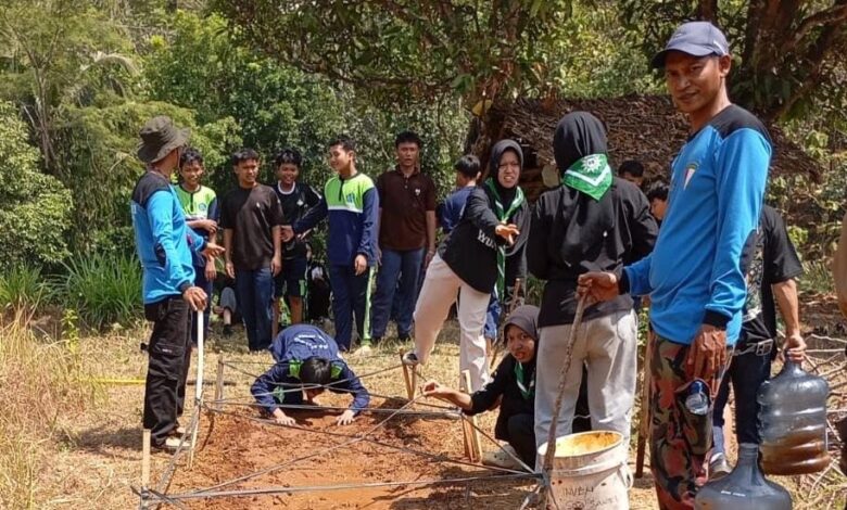 Anggota Kokam Pakis Aji mendampingi peserta pelatihan survival LDK SMA Muhammadiyah Bangsri merayap di bawah tali di Gua Sakti Plajan.