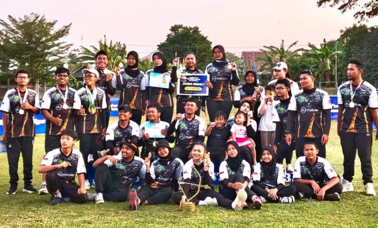 Tim Panahan Surakarta yang diperkuat mahasiswa UMS berpose bersama memegang piala juara umum dan plakat hadiah di Sirkuit VI Panahan Jawa Tengah di Klaten, mengenakan seragam oranye-hitam.