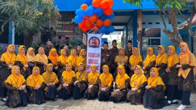 Foto bersama jajaran guru MI Muhammadiyah Plus Leksono saat peluncuran Sekolah Bernuansa Pesantren dengan balon oranye dan biru.