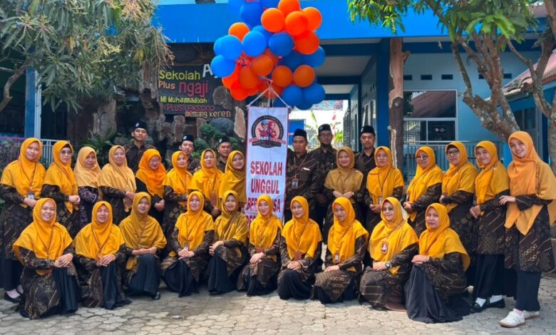 Foto bersama jajaran guru MI Muhammadiyah Plus Leksono saat peluncuran Sekolah Bernuansa Pesantren dengan balon oranye dan biru.