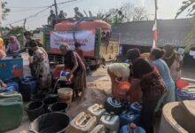 Relawan MDMC Blora mendistribusikan bantuan air bersih ke jeriken dan ember milik warga yang terdampak kekeringan di Blora.
