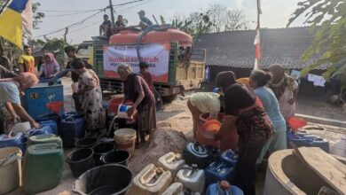Relawan MDMC Blora mendistribusikan bantuan air bersih ke jeriken dan ember milik warga yang terdampak kekeringan di Blora.